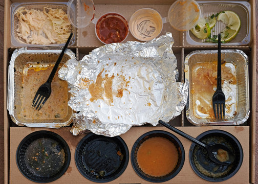 Box Of Fast Food, Empty Plates With Forks, Sauces And Aluminum Bowls Top View. Used Plastic Dishes Are Dirty After Eating In A Cardboard Box. Home Delivery Mexican Food.