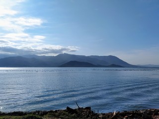 Fototapeta na wymiar Paisaje monocromático azul con lago, montañas y cielo