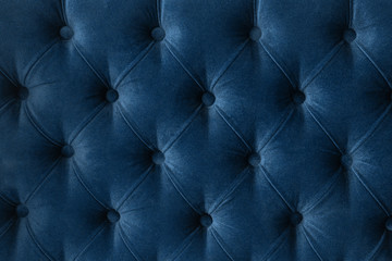 Quilted velour buttoned classic blue color fabric wall pattern background. Elegant vintage luxury...
