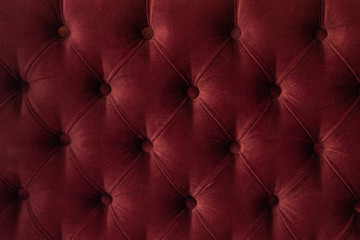 Quilted velour buttoned burgundy red color fabric wall pattern background. Elegant vintage luxury sofa upholstery. Interior plush backdrop