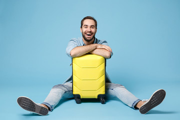 Laughing traveler tourist man in summer yellow casual clothes isolated on blue wall background....