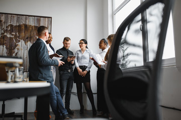 Black and white group of people discussing a diagram in office together.
