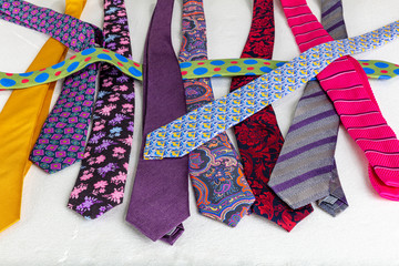 Close-up detailed background with colorful mens' neckties aqua, hot pink, burgundy, coral and...