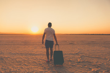 Man with luggage walking and looking for a way back on the dry salt lake. Larnaca, Greece