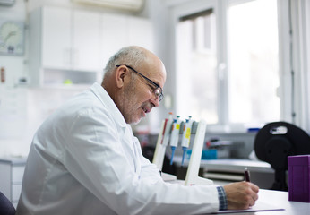 Biologist writing notes in laboratory