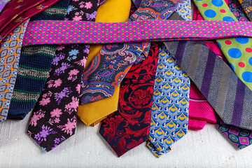 Close-up detailed background with colorful mens' neckties aqua, hot pink, burgundy, coral and...
