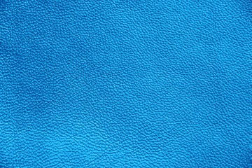 Genuine Leather. Blue background. The texture of the skin close-up.