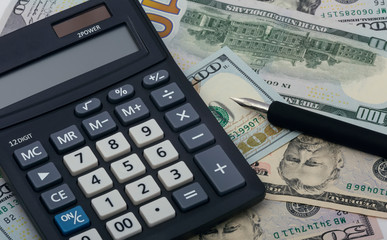 Calculator, dollars and fountain pen. Close-up.