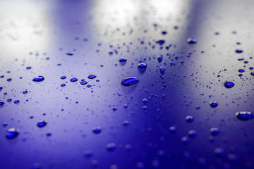 Water droplets on waterproof surface of the car vinyl film are blue purple. Texture