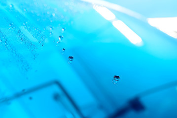 The Surface Protection of the car windows at the car wash under the jets of water. Blue tone