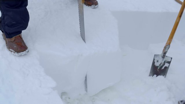 Man cuts big chunk of solid snow to make a snow sculpture in a contest