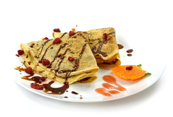 Two pancakes with fruit and chocolate dressing.