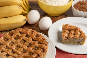Homemade banana pie with cinnamon and a golden crust, on a wooden background