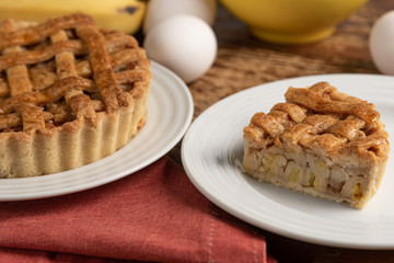 Homemade banana pie with cinnamon and a golden crust, on a wooden background