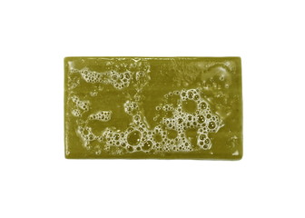 Hand made Olive Soap bar with foam isolated on white background. Wet bar of soap.
