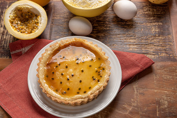 Homemade passion fruit pie with and a golden crust, on wooden background
