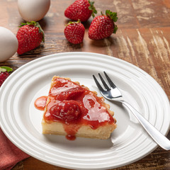 Homemade strawberry pie with and a golden crust, on wooden background