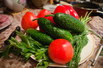 fresh spring vegetables on the table.kitchen.tomatoes, cucumbers, greens
