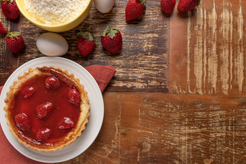 Homemade strawberry pie with and a golden crust, on wooden background