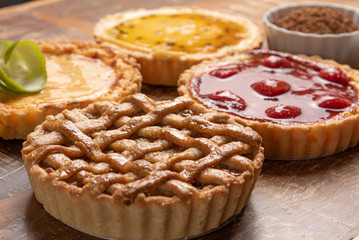 Assortment of homemade  pies with and a golden crust, on wooden background