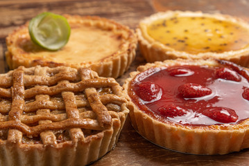 Assortment of homemade  pies with and a golden crust, on wooden background