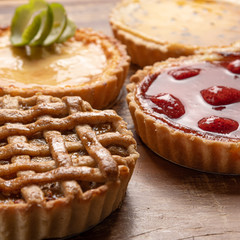 Assortment of homemade  pies with and a golden crust, on wooden background