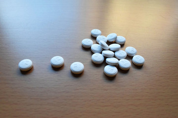Fototapeta na wymiar Scattered Pills on a Wooden Table 2