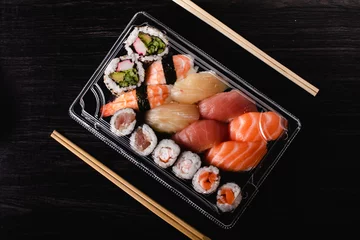 Selbstklebende Fototapeten Sushi to go concept. Takeaway box with sushi © DMegias