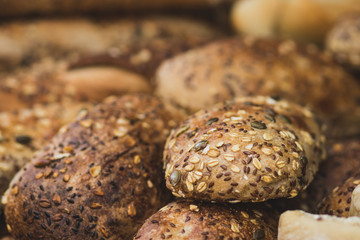 A pile of fresh baguettes made from whole flour. Coated with oats and sunflower seeds. Crispy, blurred background. The Market, Jerusalem.