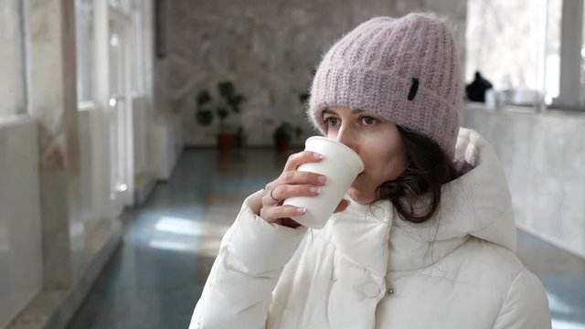 young woman drinking mineral water from a paper Cup