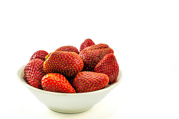 red strawberry berries in a plate on a white background, space for text