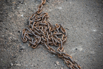 Rusty heavy chain on asphalt