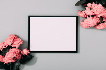 Beautiful flowers composition. Blank frame for text, pink rose flowers on gray background....