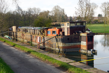 house boat, used as tiny house in alternative lifestyle, at canal of river doubs in France