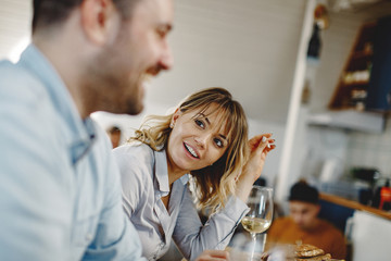 Happy woman communicating with her husband during a meal at dining table.