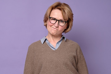 Senior caucasian woman in glasses thinking puzzled about her choice.