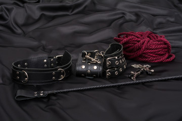 Leather handcuffs, shibari rope, nipple clamps, chain collar and stack on black