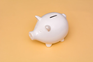 White pig piggy bank on a beige background.