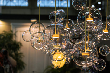 Lighting balls on the chandelier in the lamplight, light bulbs hanging from the ceiling. - Powered by Adobe