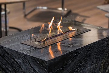 Beautiful marble black floor fireplace. Minimalism interior, alternative bio fireplot fireplace on...