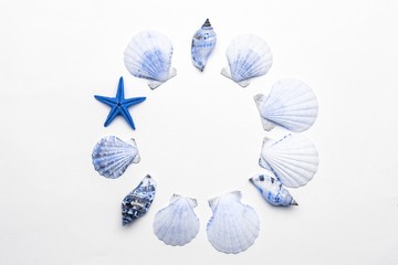 Summer time concept with trendy aquamarine light blue pastel color sea shells and starfish on white background, copy space. Flat lay, top view