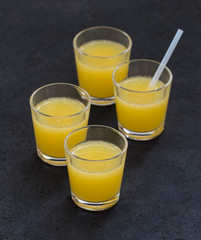 Orange drink in a glass on a dark gray background