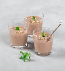 Chocolate nut jelly in a glass on a light background