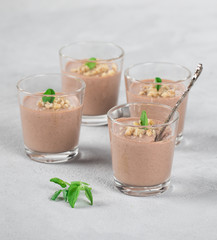Chocolate nut jelly in a glass on a light background