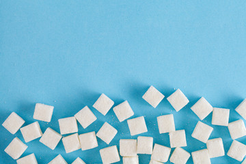 sugar cubes on pastel blue background, flat layout, top view, copy space