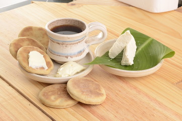 arepa de trigo venezolana con queso cuajado y taza de café caliente