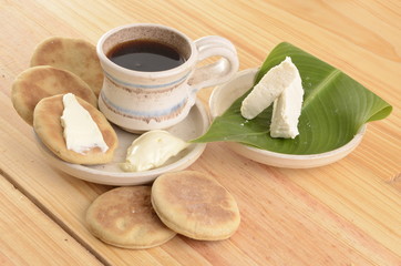 Fototapeta na wymiar arepa de trigo venezolana con queso cuajado y taza de café caliente