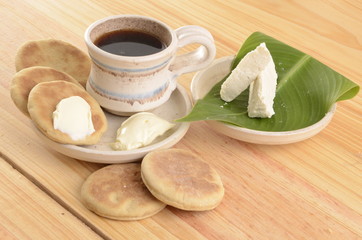 Fototapeta na wymiar arepa de trigo venezolana con queso cuajado y taza de café caliente