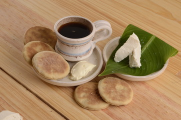 arepa de trigo venezolana con queso cuajado y taza de café caliente