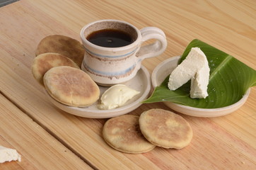 arepa de trigo venezolana con queso cuajado y taza de café caliente